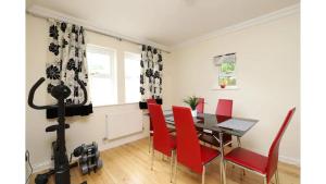 a dining room with a table and red chairs at Pass the Keys Central Oxford 2 Bed Apartment with Parking in Oxford