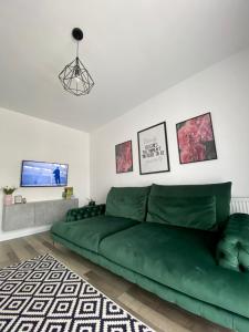 zieloną kanapę w salonie z telewizorem w obiekcie Velvet Studio w mieście Târgu Mureş