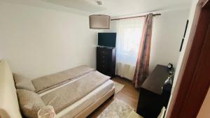 um pequeno quarto com uma cama e uma janela em Oli's Mountain Apartment em Buşteni