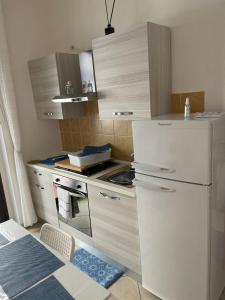 eine Küche mit einem weißen Kühlschrank und einem Herd in der Unterkunft Corso Umberto Apartment in Soverato Marina