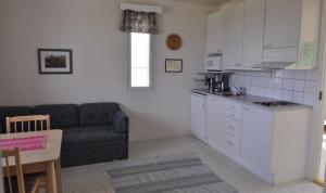 a living room with a couch and a kitchen at Lomamaja Pekonen Apartments in Muonio