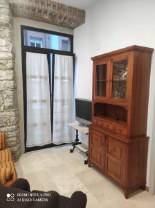 uma sala de estar com uma televisão e um armário de madeira em Prado-Gijon em Gijón