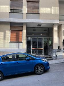 Lycabettus Luxury Cave greendom في أثينا: سيارة زرقاء متوقفة أمام مبنى