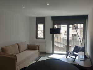 - un salon avec un canapé et une grande fenêtre dans l'établissement Apartament Cèntric a Ribes de Freser Vall de Núria, à Ribes de Freser
