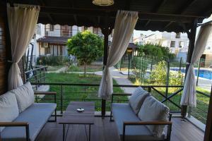 a porch with two couches and a table with a view at VİLLA ALP'S TRİPLEX LAGOON HAVUZ OLANAĞI SUNAN in Belek
