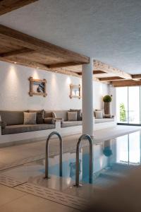 uma piscina num quarto com um sofá e uma mesa em Residence Cesa Sassela em Ortisei