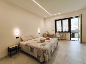 A, C or D - MyAostaProject Rentals في أَويستا: غرفة نوم بسرير ونافذة كبيرة