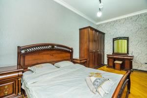1 dormitorio con 1 cama grande y vestidor en Nizami Street 2 Room Gold Home, en Baku