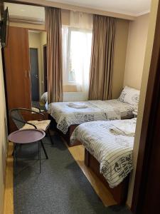 a hotel room with two beds and a window at Hotel Maria in Tbilisi City