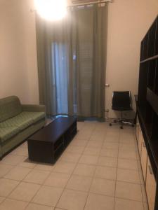 ein Wohnzimmer mit einem Sofa und einem Tisch in der Unterkunft A casa di Flavia in Catania
