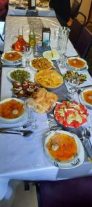un lungo tavolo con piatti di cibo sopra di Guesthouse Nakudurta a Dart'lo