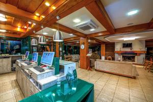 a restaurant with a counter with laptops on it at Hotel Laghetto Toscana in Gramado