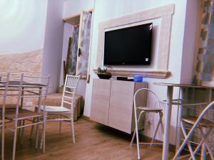 sala de estar con sillas y TV de pantalla plana en LE ANTICHE MURA, en Vallecorsa