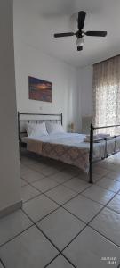 een slaapkamer met een bed en een plafondventilator bij San Giorgio in Litóchoron