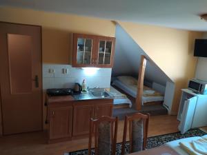 a small kitchen with a sink and a staircase at Chalupa pod lipami in Terchová