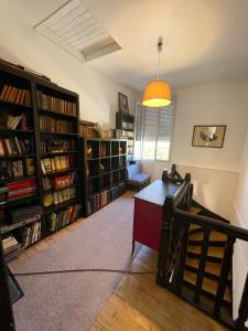 um quarto com estantes de livros e uma secretária num quarto em La Terrasse du Colombier em Limoges