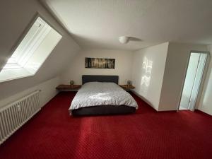 1 dormitorio con 1 cama y alfombra roja en Ferienwohnung Schwarzwald, en Hinterzarten