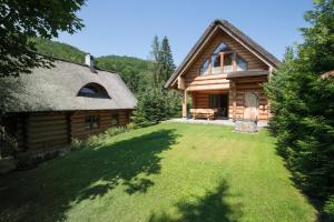 a log cabin with a grass yard in front of it at Dom z Bali VENUS in Międzybrodzie Żywieckie