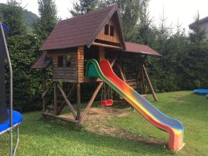 un parque infantil con una casa y un tobogán en Chalupa pod lipami en Terchová