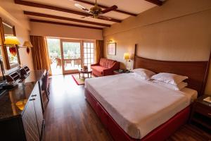 a bedroom with a bed and a living room at The Carlton Kodaikanal in Kodaikānāl