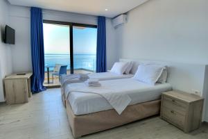 a bedroom with a large bed with a view of the ocean at Sea View Hotel in Sarandë