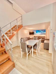 une salle à manger avec une table, des chaises et un escalier dans l'établissement Flors Apartments, à Durrës