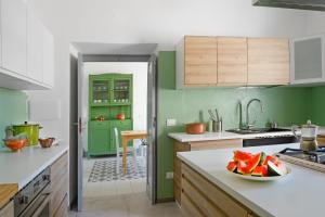 a kitchen with green walls and a bowl of fruit on a counter at Casa Mediterranea in Nurachi +23 photos