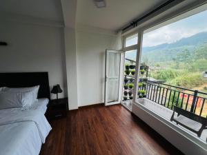 a bedroom with a bed and a large window at Dream Stay Green in Nuwara Eliya