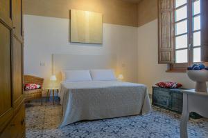 een slaapkamer met een bed, een tafel en een raam bij Casa Mediterranea in Nurachi