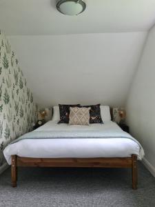 Cama en habitación con pared blanca en Park House Self-Contained Annex en Mold