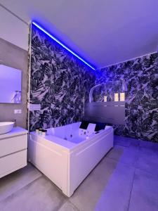 La salle de bains est pourvue d'une grande baignoire et d'un papier peint noir et blanc. dans l'établissement CA.FOSCARI HARMONY, à Milan