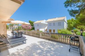 un patio con mesa, sillas y sombrilla en YourHouse Villa Canta town house, en Playa de Muro