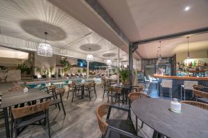 a restaurant with tables and chairs and a pool at Makris Yialos Apartments in Lassi