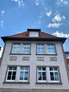 un edificio con 4 ventanas y techo rojo en Kläve12 Guesthouse, en Oldenburg