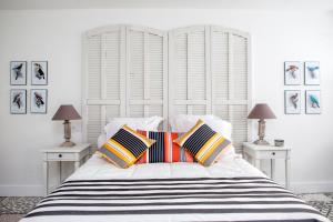 a white bedroom with a large white bed with pillows at L’annexe in Orange