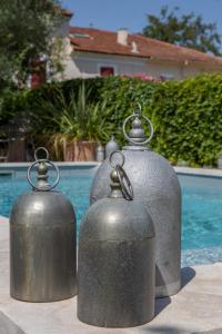 a couple of metal containers sitting next to a pool at L’annexe in Orange