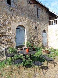 een tafel en stoelen voor een bakstenen gebouw bij Maris Domus près des plages du débarquement in Bayeux