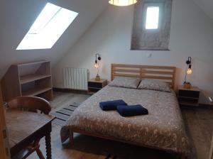 a bedroom with a bed with two blue pillows on it at Maris Domus près des plages du débarquement in Bayeux