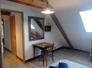 een eetkamer met een tafel en een spiegel bij Maris Domus près des plages du débarquement in Bayeux