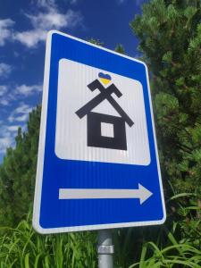 a blue sign with a bird on top of a house at Mikalojiskis in Inturkė