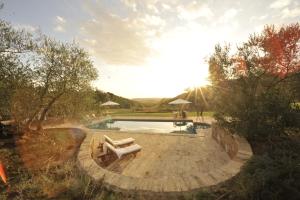 a pool with two lounge chairs in a yard at Tenuta Santo Pietro in Pienza