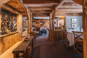 un restaurante con paredes de madera, mesas y sillas de madera en La Maison Les Peupliers en Courchevel