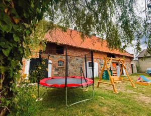 un parque infantil frente a una casa de ladrillo en Agroturystyka Szerokopaś en Nidzica