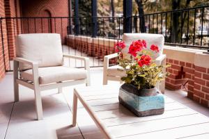 two chairs and a vase with flowers on a porch at Brick Castle - Apartament Ulrich in Wrocław