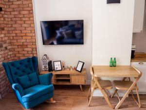 a living room with a blue chair and a table at Brick Castle - Apartament Ulrich in Wrocław