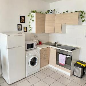 uma cozinha com uma máquina de lavar roupa e uma máquina de lavar louça em F2 1 Lovely room, Living and bathroom shared, St Julians em St. Julian's