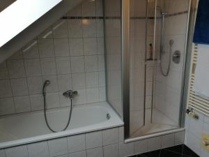 Das Bad ist mit einer Dusche und einer Badewanne ausgestattet. in der Unterkunft Gästehaus Brunnerhof - Reisen in Eitting