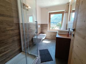 a bathroom with a shower and a toilet and a window at Les Flocons Pila in Pila