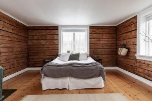 a bedroom with wooden walls and a bed in it at Charming Villa at Askersund Golf Resort in Åmmeberg