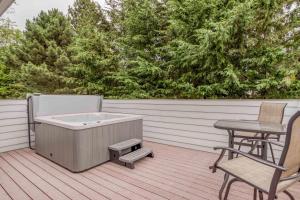 a hot tub on a deck with a table and chairs at Family Tides - Meredith Lodging in Neskowin